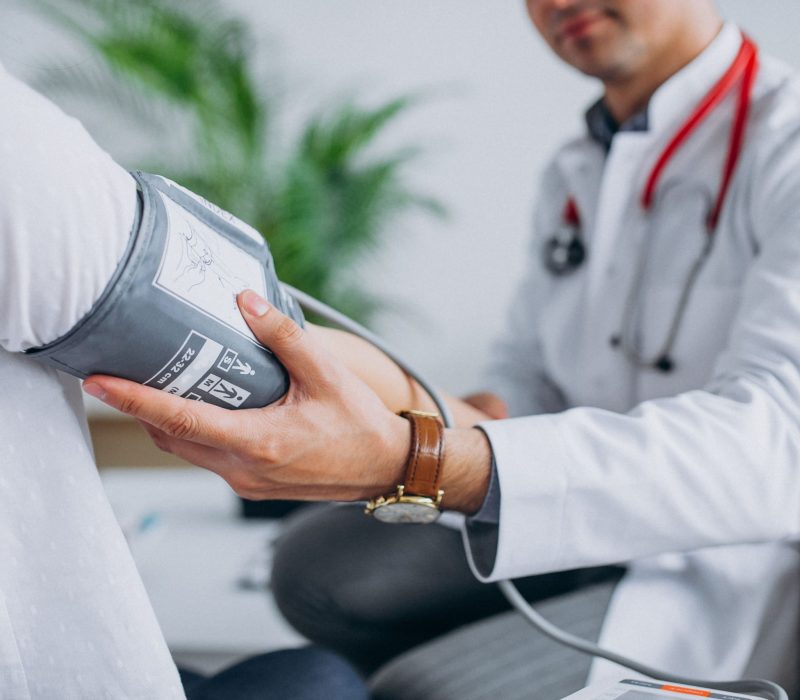 young-male-psysician-with-patient-measuring-blood-pressure
